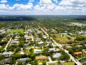 Sign reading 'Fianzas en Pinecrest, FL' against a backdrop of a vibrant, sunny street.